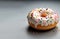 Round sweet baked donuts with shiny glaze and multicolored sprinkles on light background