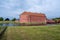 The round tower and the red brick facade of Landskrona castle and its surrounding moat