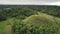 Round unique hill in middle of Chocolate Hills aerial view. Similar mounts with wide green meadows