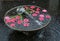 Round water fountain with fish and red flowers floating