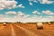 Round wheat hay bales drying in field stubble after harvest