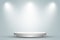 Round white podium or pedestal in studio room with spotlight in gray background.