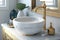 round white wash basin with brass faucet and towel bar