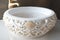 round white wash basin with elaborate gold accents and delicate designs