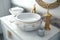 round white wash basin with gold accents and elegant silver accessories