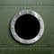 Round window porthole on green metal background. Military armor