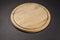 Round wooden breadboard on grey