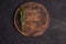 Round wooden cutting board on a black table. Top view of empty kitchen trendy rustic wooden tray