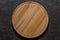 Round wooden pizza stand board, top view dark background, with space to copy text