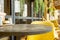 Round wooden table and cozy yellow chair at street cafe