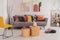 Round, wooden tables standing in front of a gray couch with colorful pillows in bright living room interior