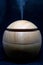 A round wooden texture Humidifier spreading steam into the living room. Ultrasonic humidifier atomizes water vapor. Humidification
