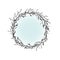 Round Wreath with black branches and twigs. Spring garland with light blue sky.