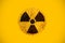 Round yellow and black radioactive hazard ionizing radiation nuclear danger warning symbol on rusty metal grungy texture