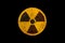 Round yellow and black radioactive ionizing radiation nuclear danger symbol on rusty metal grungy texture and isolated on black