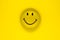 Round and yellow smiling face on yellow background surface