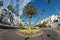 Roundabout with canarian palm tree in the center in the tourist resort Playa de las Americas. Super wide angle panoramic view.