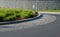 Roundabout of gray granite cubes closer to the center. beveled concrete curbs with flowers and grass in the middle of the circle.