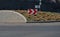 Roundabout of gray granite cubes closer to the center. beveled concrete curbs with flowers and grass in the middle of the circle.