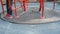 Roundabout merry go round spinning on empty playground with its shadow, red carousel