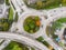 Roundabout road intersection with vehicle traffic and green trees aerial view from drone showing circular shape and lanes,