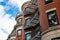 Rounded faces of brownstone apartments with bridges of metal balconies