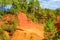 Roussillon ochre deposit: Beautiful orange hills and lush green pines.