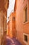 Roussillon village, urban street and red facades . Luberon, Provence,