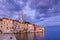 Rovinj town with multicolored buildings and yachts moored along embankment, Croatia.