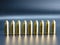 Row of 9 mm pistol bullets on dark background