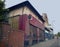 A row of abandoned stores with boarded up shop fronts with crumbling facades and peeling paint in an urban road