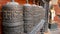 Row of aged religious prayer wheels or drums with mantra Om Mani Padme Hum in yard of temple, Durbar Square, Nepal