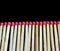 Row of aligned fire matchsticks on black background