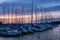 Row of anchored sailing boats in purple evening sunlight