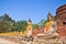 A row of ancient buddha statues in front of ruin pagoda