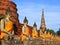 A row of ancient buddha statues in front of ruin pagoda