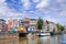 Row of ancient renovated mansions and a canal with passage way, Amsterdam, Netherlands