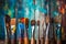 Row of artist paintbrushes closeup on artistic wooden background. Brushes with colorful paints