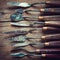 Row of artist palette knifes on old wooden table