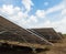 Row of back side view photovoltaic solar panels / modules at solar power station