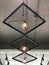 Row of bare modern hanging lamps under cement ceiling