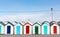 Row of beach huts with colourful red blue and green doors