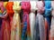 Row of a Beautiful Colored woman's scarves tied knot to the rack hanging in store.