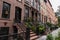 Row of Beautiful Old Brownstone Homes and Residential Buildings in Chelsea of New York City along the Sidewalk