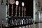 Row of beer taps on a stainless steel keg in a pub