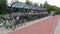 Row of bicycles parked in covered bike rack shelter with a cycle lane. Woman riding