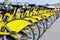 Row of bicycles parked. Row of parked colorful bicycles. Rental yellow bicycles. Pattern of vintage bicycles bikes for rent