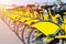 Row of bicycles parked. Row of parked colorful bicycles. Rental yellow bicycles. Pattern of vintage bicycles bikes for rent on