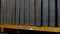 Row of big old black books on a bookshelf in library.