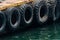 Row of black car tires used as boat bumpers